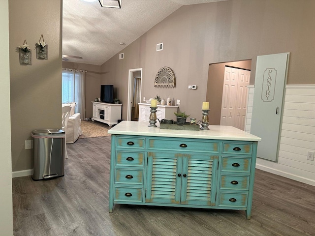 kitchen featuring green cabinets, a textured ceiling, dark wood-type flooring, and lofted ceiling