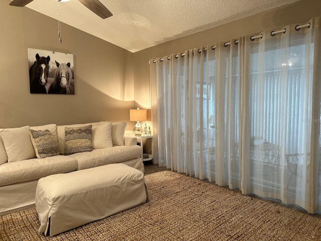 carpeted living room featuring a textured ceiling and ceiling fan