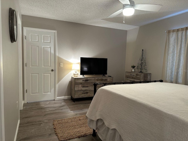 bedroom featuring a textured ceiling, ceiling fan, and hardwood / wood-style flooring