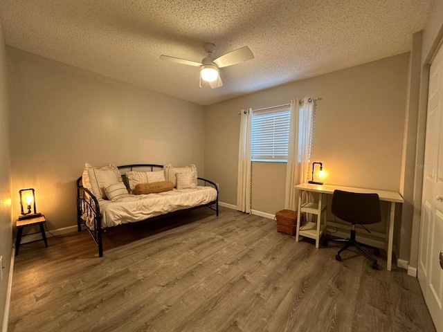 bedroom with hardwood / wood-style floors, a textured ceiling, and ceiling fan