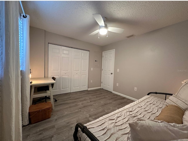 bedroom featuring a closet, ceiling fan, a textured ceiling, and dark hardwood / wood-style flooring