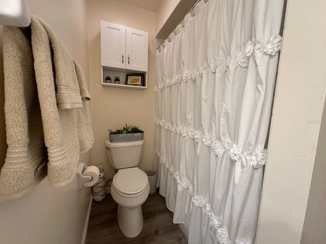 bathroom with toilet and hardwood / wood-style flooring