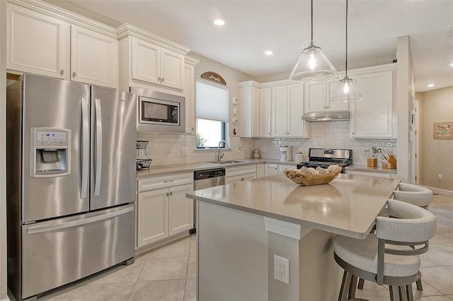 kitchen featuring white cabinets, tasteful backsplash, stainless steel appliances, and a kitchen island