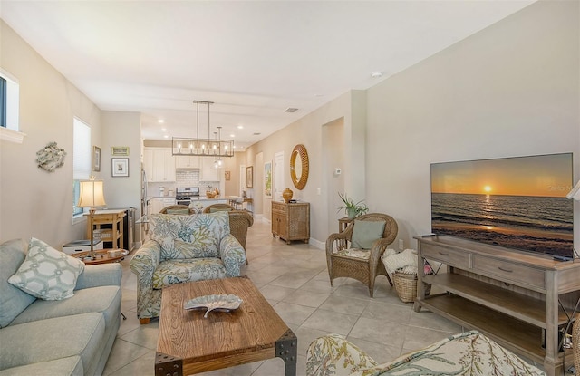 tiled living room featuring a notable chandelier