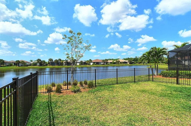 view of yard with a water view and glass enclosure