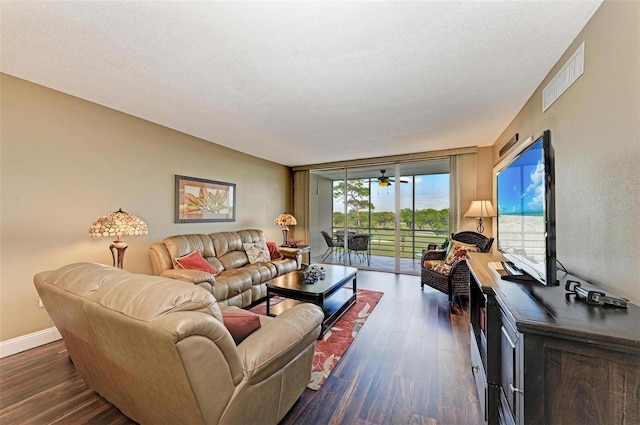 living room featuring dark hardwood / wood-style flooring, a textured ceiling, and ceiling fan