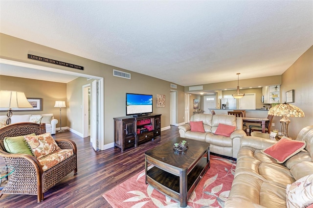 living room featuring dark hardwood / wood-style flooring and a textured ceiling