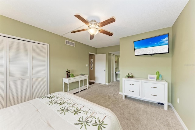 carpeted bedroom with a closet and ceiling fan