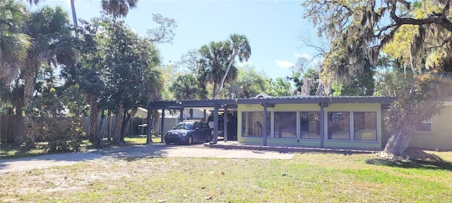 back of property featuring a carport and a yard