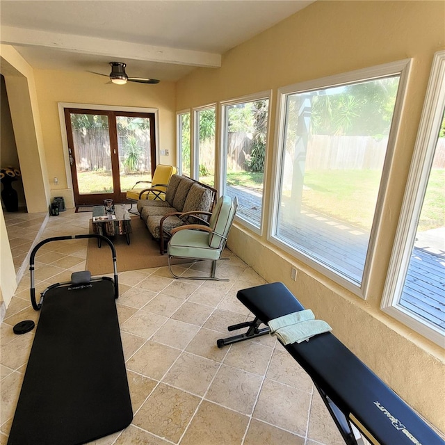 exercise room featuring light tile floors and ceiling fan