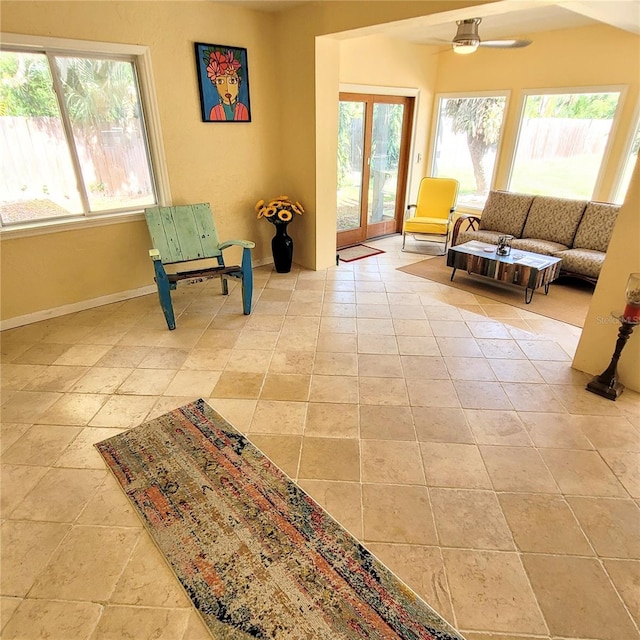 sitting room featuring french doors, light tile flooring, and ceiling fan