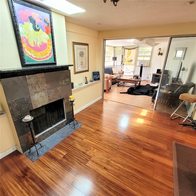 living room featuring light hardwood / wood-style flooring and a tiled fireplace