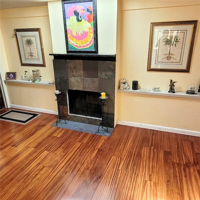 living room featuring hardwood / wood-style flooring and a tiled fireplace