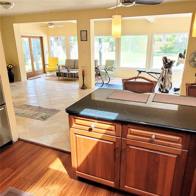 kitchen featuring light tile floors, french doors, ceiling fan, and a wealth of natural light