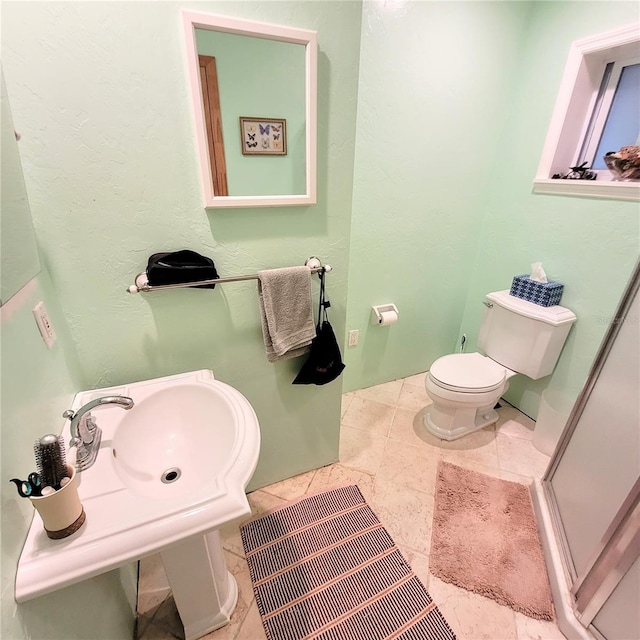 bathroom featuring toilet, tile floors, and sink