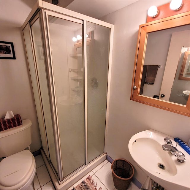 bathroom with walk in shower, tile floors, toilet, and sink