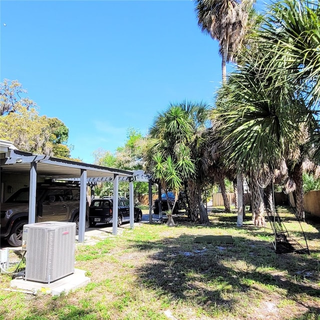 view of yard with a carport and central AC