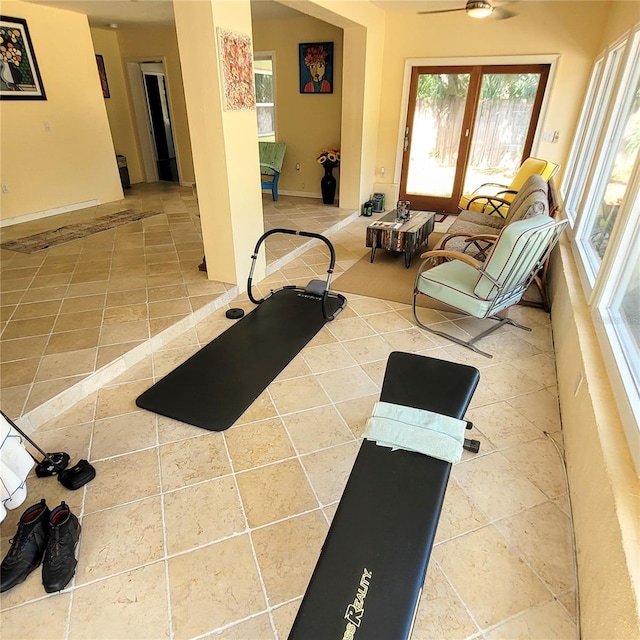 exercise room with light tile flooring and ceiling fan