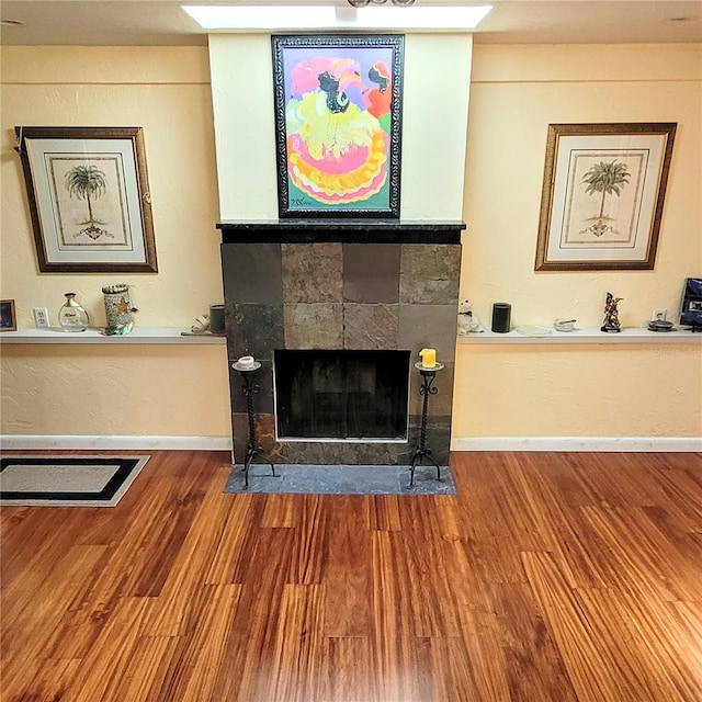 living room featuring dark wood-type flooring and a tile fireplace