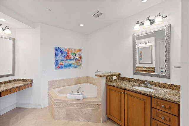 bathroom featuring vanity, tiled tub, and tile patterned flooring