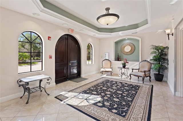 tiled foyer with a tray ceiling