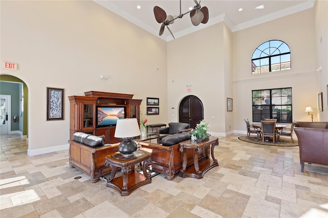 living room featuring crown molding, a towering ceiling, and ceiling fan