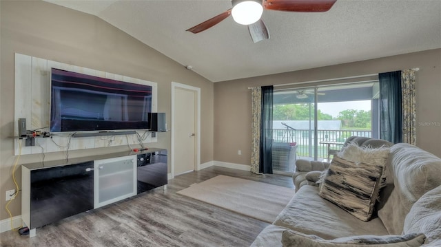 living room featuring wood-type flooring, ceiling fan, and vaulted ceiling