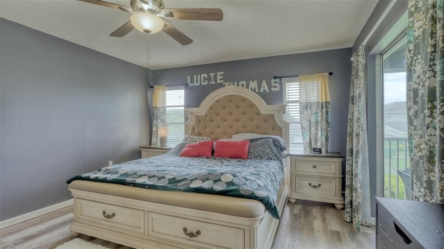 bedroom with ceiling fan, a textured ceiling, and light wood-type flooring