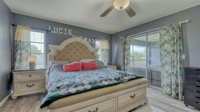 bedroom featuring light hardwood / wood-style floors, ceiling fan, access to outside, and a textured ceiling