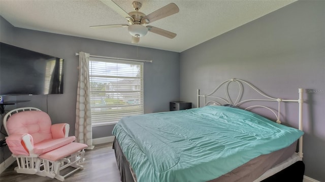 bedroom with dark wood-type flooring, ceiling fan, and a textured ceiling