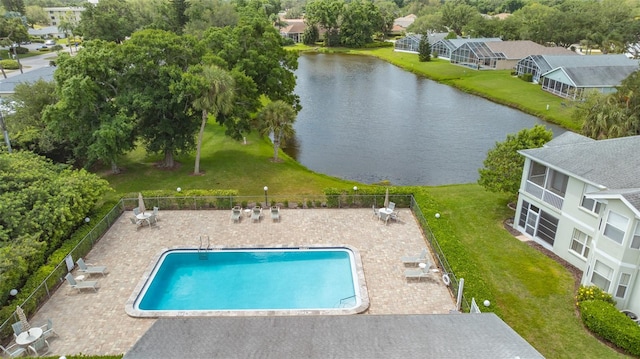 view of pool with a patio, a yard, and a water view