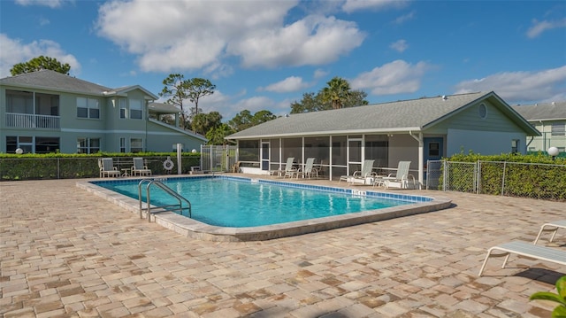 view of swimming pool with a patio and a sunroom