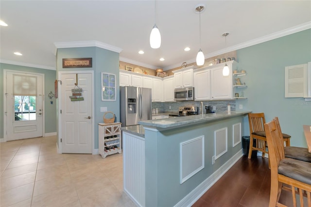 kitchen with crown molding, hanging light fixtures, appliances with stainless steel finishes, tasteful backsplash, and white cabinetry