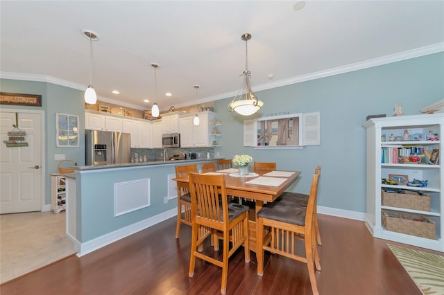 dining space with dark tile floors and crown molding