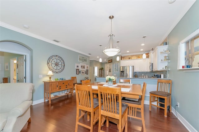 dining area with crown molding and dark hardwood / wood-style flooring