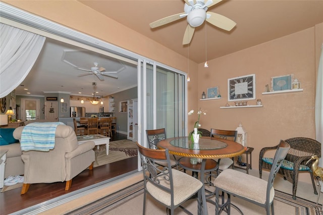 dining space with hardwood / wood-style floors and ceiling fan