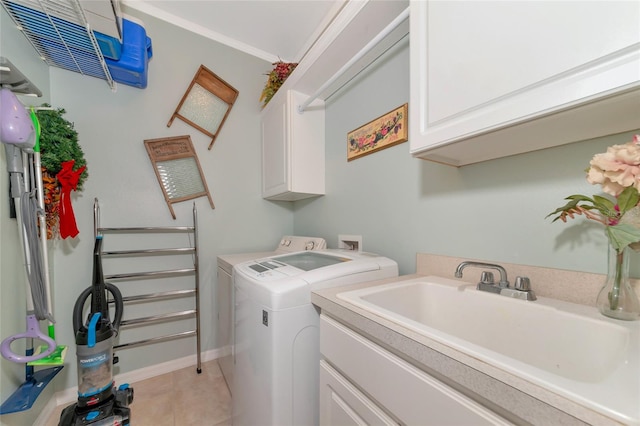 clothes washing area with light tile floors, separate washer and dryer, cabinets, crown molding, and sink