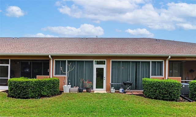 rear view of property featuring a lawn