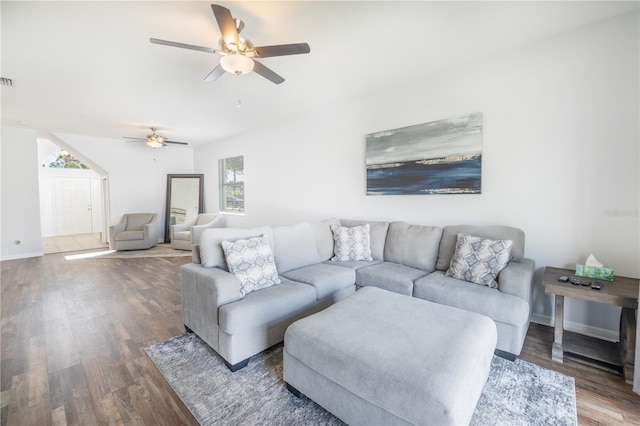 living room with ceiling fan and dark wood-type flooring