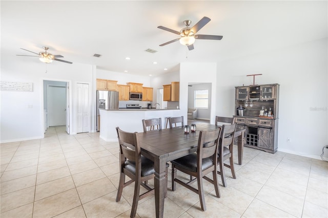 dining room featuring light tile floors, ceiling fan, and sink