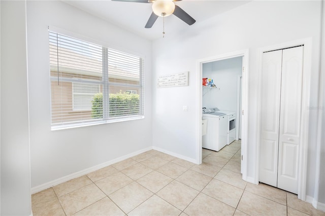 tiled empty room with washer and clothes dryer and ceiling fan