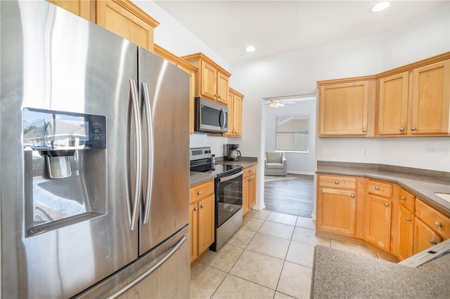 kitchen featuring light tile floors, appliances with stainless steel finishes, and ceiling fan