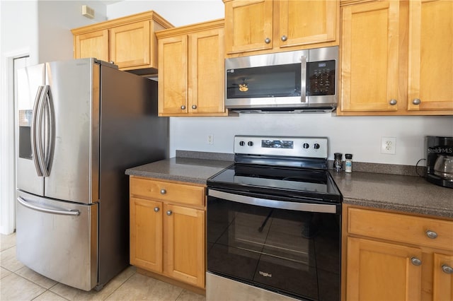 kitchen featuring light tile floors and appliances with stainless steel finishes