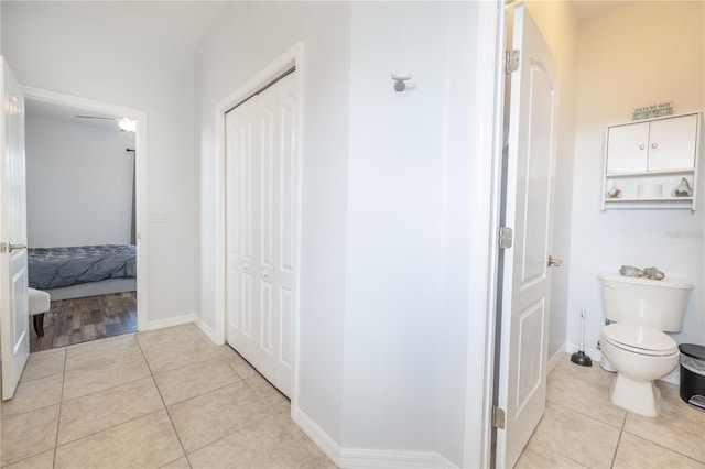 bathroom featuring toilet, tile floors, and ceiling fan