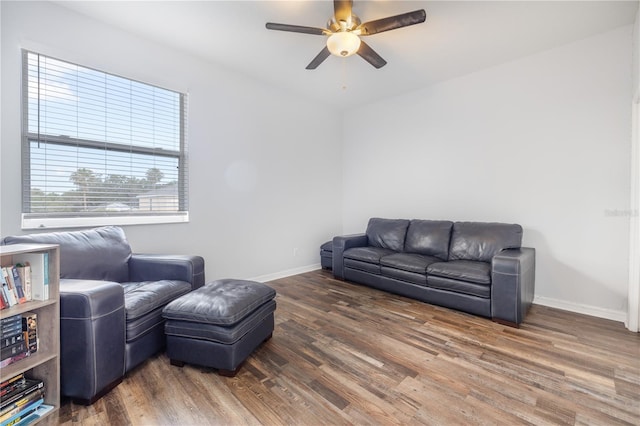 living room featuring ceiling fan and dark hardwood / wood-style flooring