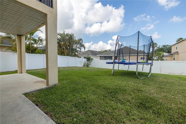 view of yard featuring a trampoline and a patio