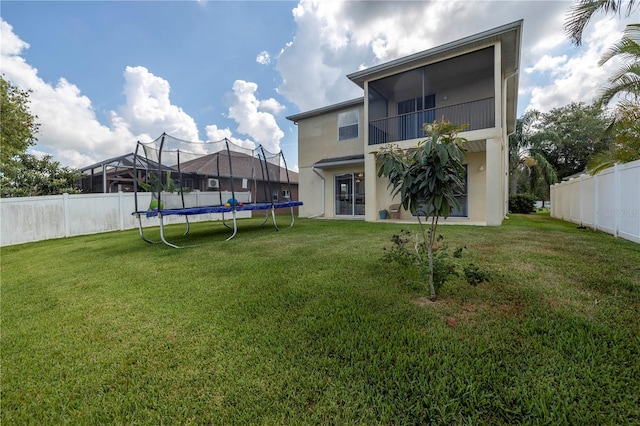 view of yard featuring a balcony and a trampoline