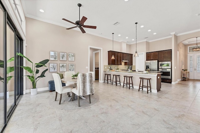 dining area with ornamental molding, ceiling fan, and light tile flooring