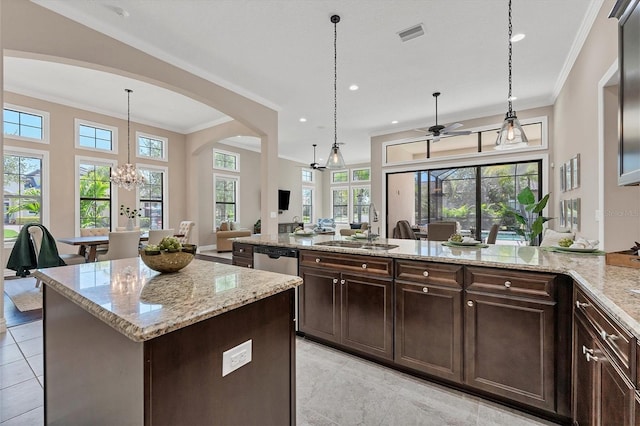 kitchen with hanging light fixtures, a healthy amount of sunlight, and light stone countertops