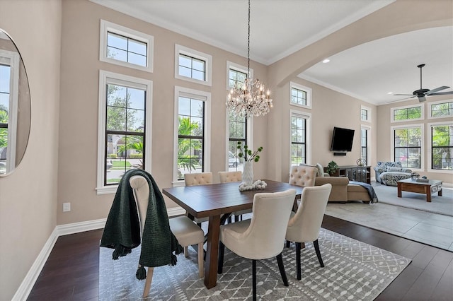 dining space with dark hardwood / wood-style floors, ornamental molding, and ceiling fan with notable chandelier